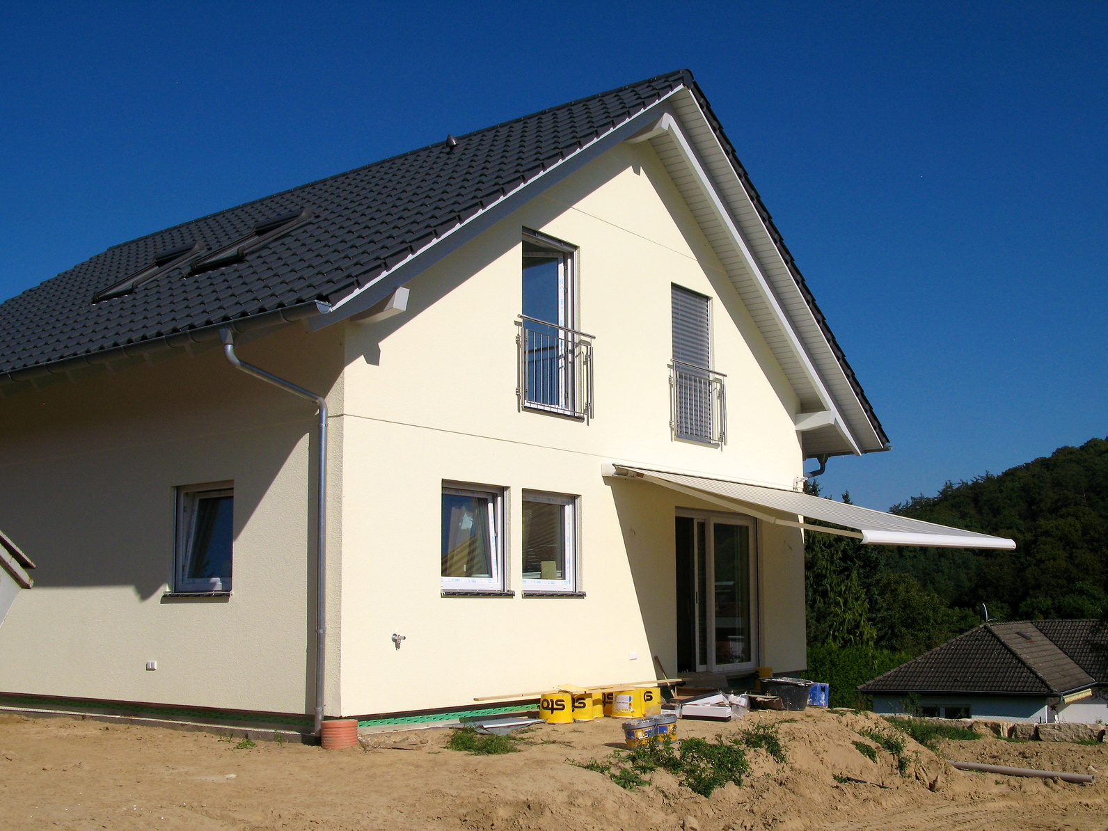 Gelbes Einfamilienhaus mit Markise